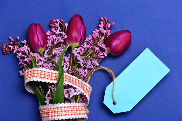 Flores de tulipán y lila con cinta a cuadros y etiqueta cian — Foto de Stock