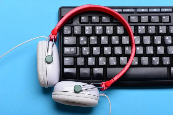 Earphones in red and white with computer keyboard