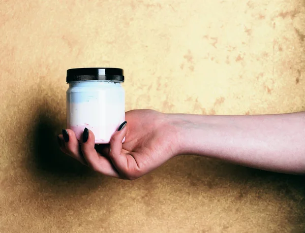 Λευκό βάζο με λοσιόν ή μπάνιο αλάτι στο γυναικείο χέρι — Φωτογραφία Αρχείου