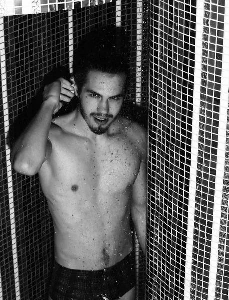 Yakışıklı adam duşta yıkanıyor.