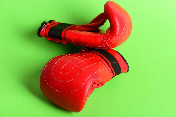 Leather sport boxing gloves in red color isolated on green
