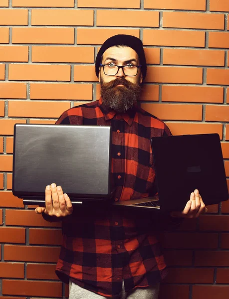 Barbudo brutal caucasiano hipster segurando laptops — Fotografia de Stock