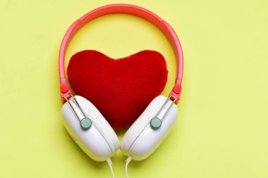 Beyaz ve kırmızı renkli yumuşak oyuncak kalp ile kulaklıklar