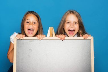 Mavi arka planda okul üniformalı kızlar