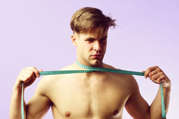 裸の胴を持つ男と紫の背景にテープを測定 — ストック写真