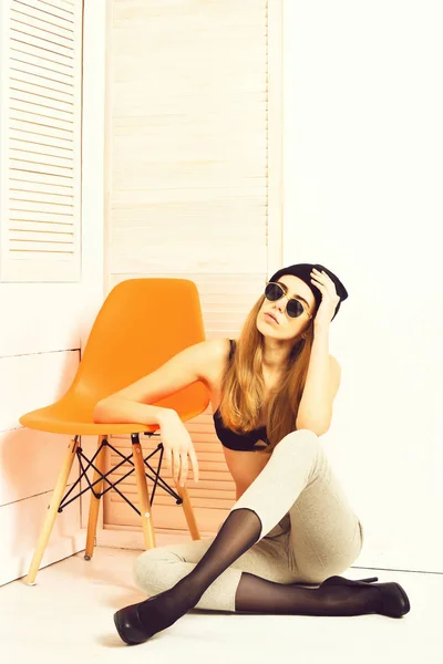 Vacker sexig kvinna i solglasögon, behå, hatt på orange stol — Stockfoto
