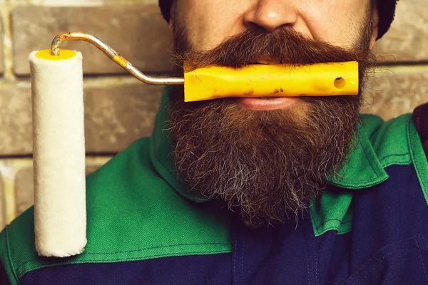 Homem pintor barbudo segurando pintura de rolo com rosto sério — Fotografia de Stock