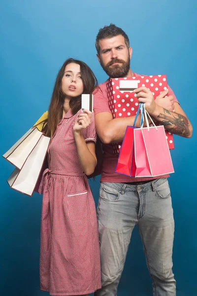 Birbirini seven çiftler sırt sırta verip alışveriş torbalarını tutarlar.