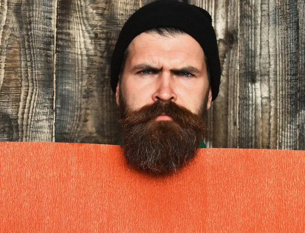 Skäggig brutal kaukasisk hipster med rött pappersark — Stockfoto