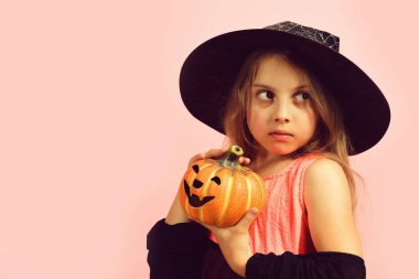 Cadı kostümü giymiş çocuk ve Jack O Lantern.