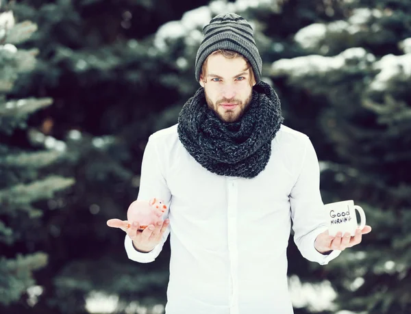 Hombre guapo con moneybox y taza en invierno al aire libre — Foto de Stock