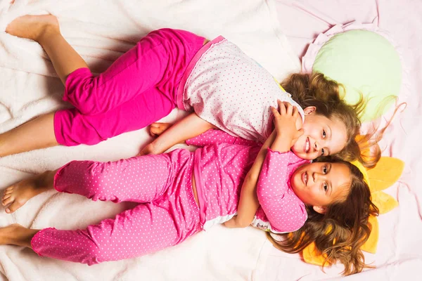 Schoolgirls having pajama party. Kids in pink pajamas