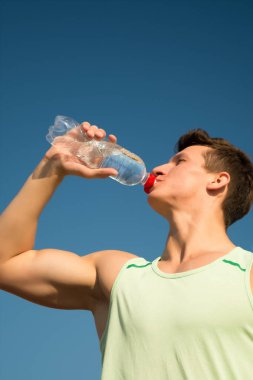 Mavi gökyüzü üzerinde yeşil tshirt atlet.