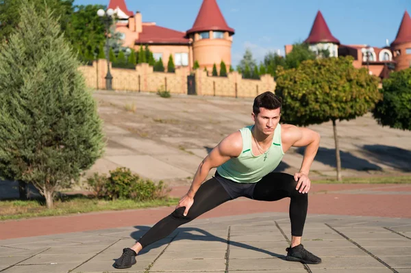 Hombre estirando y calentando los músculos antes del entrenamiento — Foto de Stock