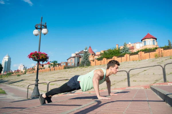 Macho fazendo flexões em escadas de tijolo vermelho ao ar livre — Fotografia de Stock