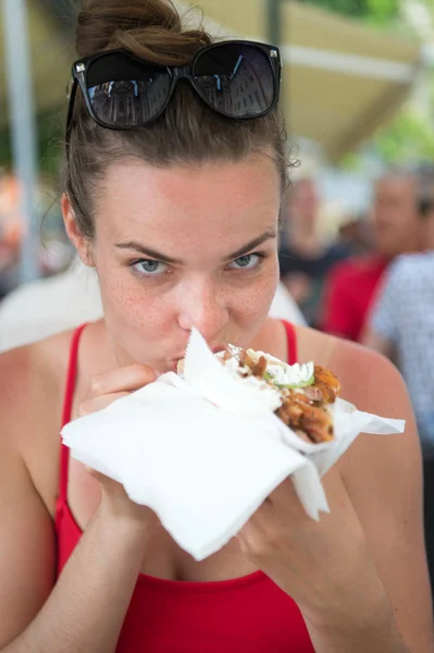 幸せなpreatty女の子または女性食べるサンドイッチジャイロ. — ストック写真