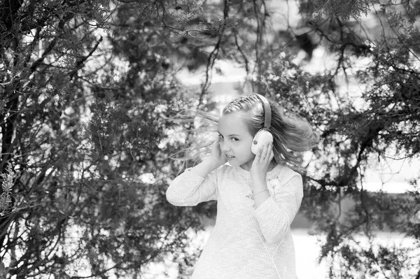 Linda niña disfrutando de la música usando auriculares —  Fotos de Stock