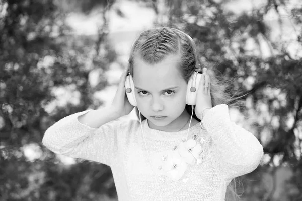 Linda niña disfrutando de la música usando auriculares — Foto de Stock