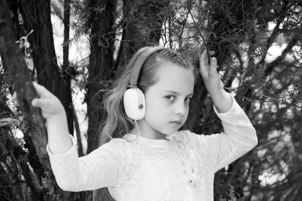 Linda niña disfrutando de la música usando auriculares — Foto de Stock