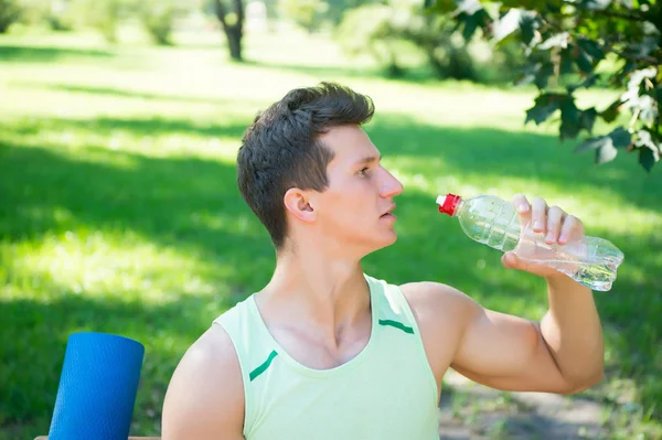Sporcu içme suyu güneşli doğal yaz peyzaj üzerinde — Stok fotoğraf