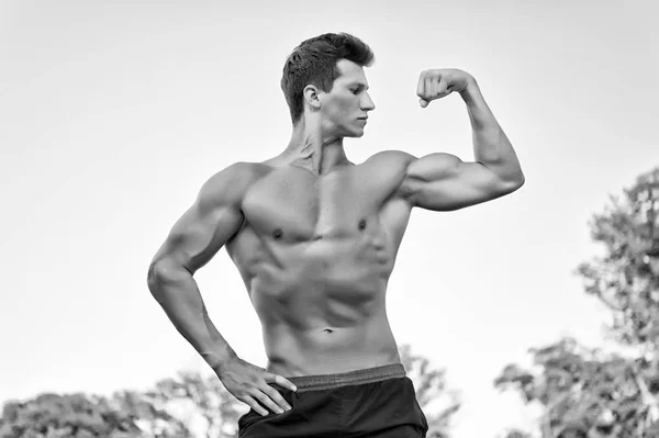 Man or sportsman flexing arm on sky — Stock Photo, Image