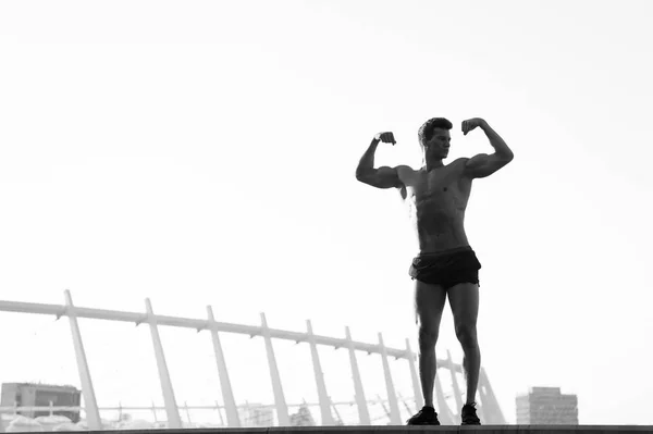 Hombre con cuerpo musculoso en cielo despejado —  Fotos de Stock