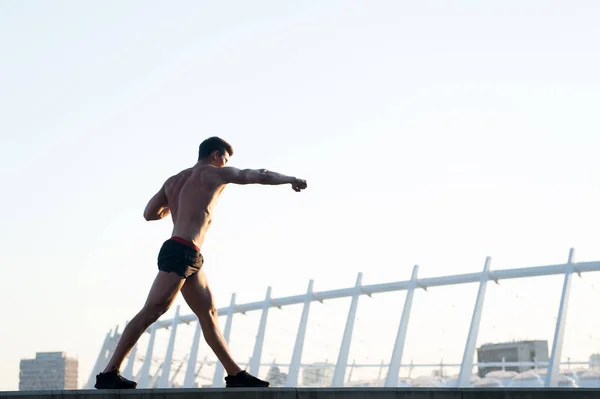 Спортсмен с мускулистым телом на белом небе — стоковое фото