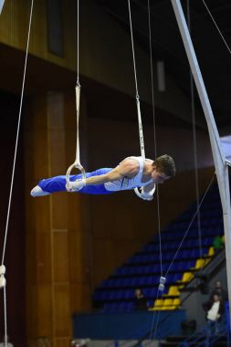 Erkek jimnastikçi sabit jimnastik halkaları gerçekleştirme