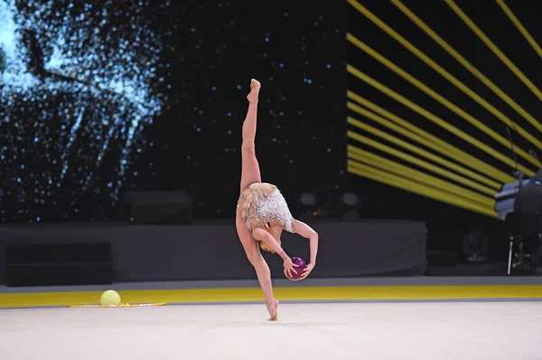Гимнастка выступает на соревнованиях по художественной гимнастике — стоковое фото