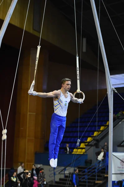 Male gymnast performing on stationary gymnastic rings — Stock Photo, Image