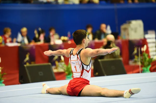 Gimnasta masculino que actúa durante la competencia — Foto de Stock