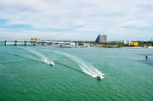 Моторные лодки, плавающие по зеленой морской воде в Майами, США — стоковое фото