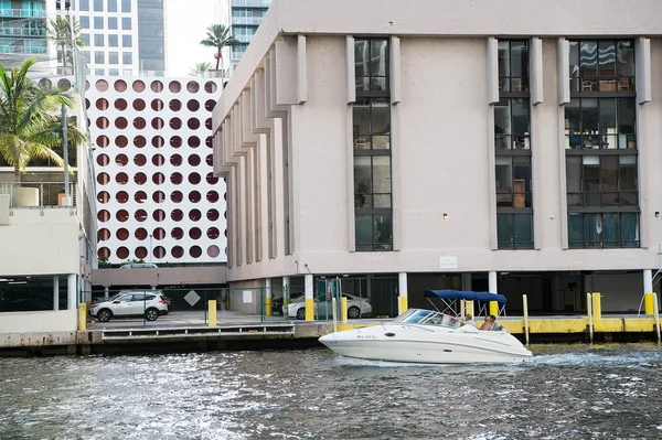 Motor boat floating on water surface on cityscape background — Stock Photo, Image