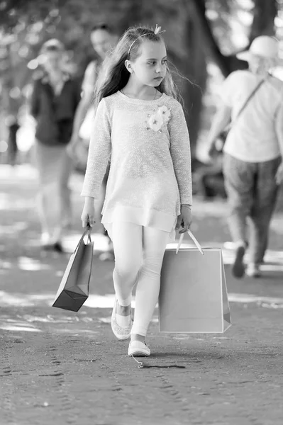 可愛い女の子がピンクの買い物袋を持って歩く — ストック写真