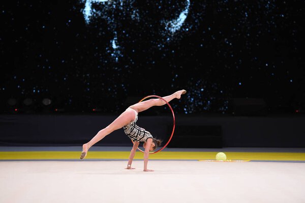 гимнастка выступает на соревнованиях по художественной гимнастике
