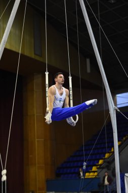 Erkek jimnastikçi sabit jimnastik halkaları gerçekleştirme