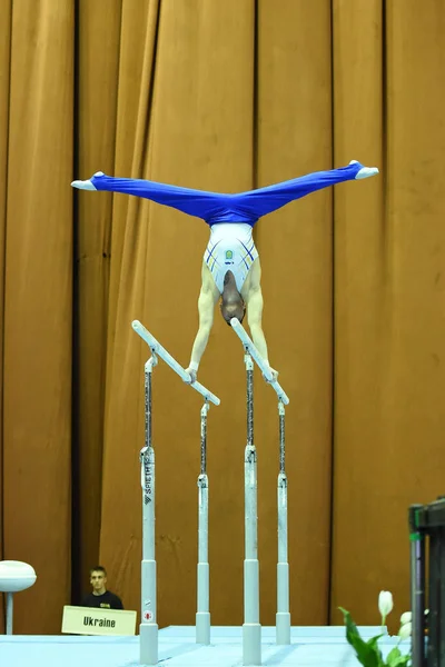 Gimnastyk wykonuje podczas konkursu — Zdjęcie stockowe