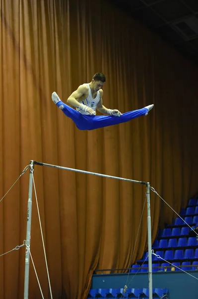 Gimnasta masculino que actúa durante la competencia — Foto de Stock