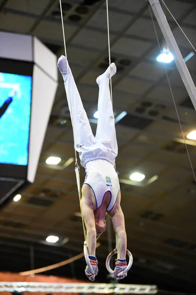 Erkek jimnastikçi sabit jimnastik halkaları gerçekleştirme — Stok fotoğraf