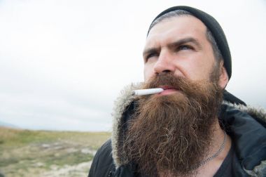 Adam ile uzun sakal saç ve bıyıklı duman Sigara