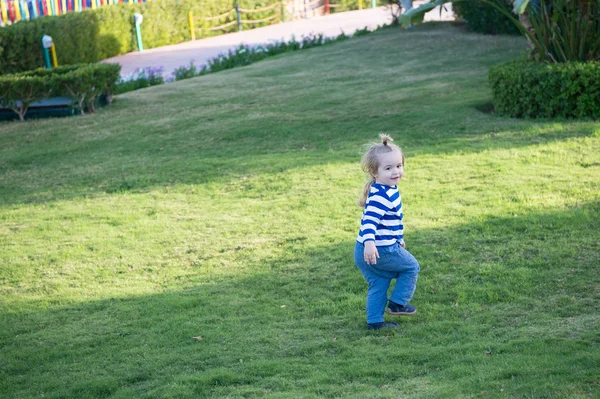 Ragazzo con i capelli biondi correre su erba verde — Foto Stock