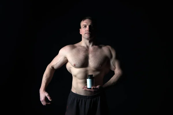 Atletische bodybuilder geïsoleerd op zwarte achtergrond. — Stockfoto