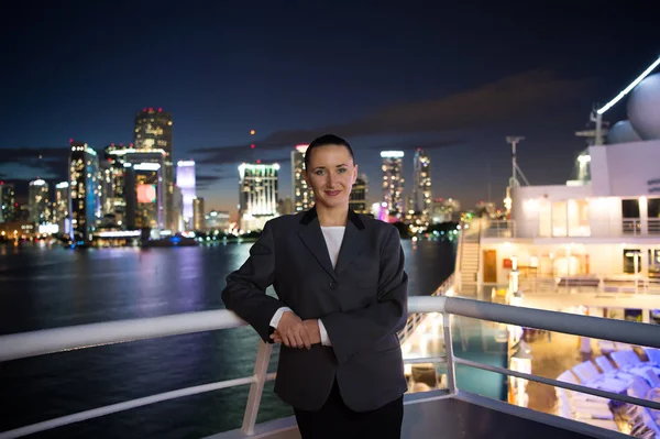 Mujer sonrisa en chaqueta gris en el balcón en Miami, EE.UU. — Foto de Stock