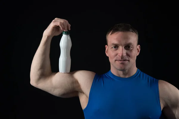 Uomo con corpo muscolare e bicipiti tenere bottiglia di yogurt — Foto Stock