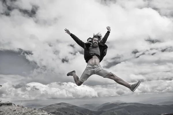Hipster com o salto de cara feliz em montanhas — Fotografia de Stock