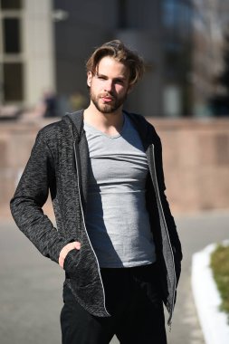 Elleri cepte olan adam sıradan kıyafetler giyer.