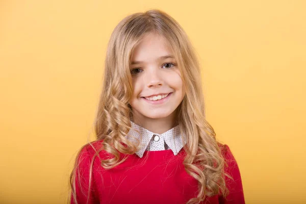 Barn med lockigt blont hår på orange bakgrund — Stockfoto