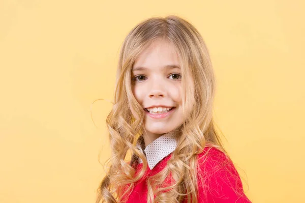 Criança com cabelo louro encaracolado no fundo laranja — Fotografia de Stock