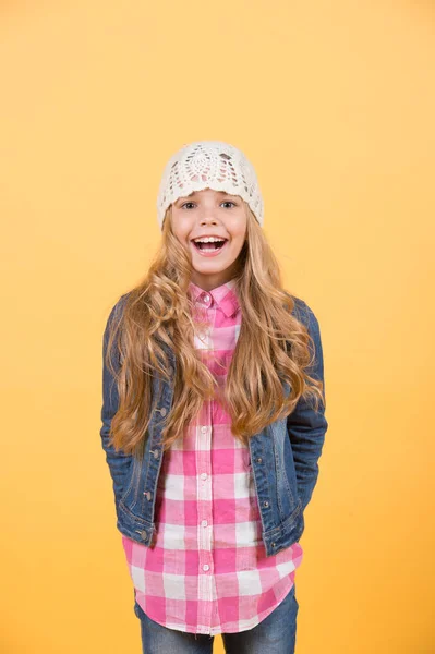 Meisje in jeans pak, hoed, geruit shirt op oranje achtergrond — Stockfoto