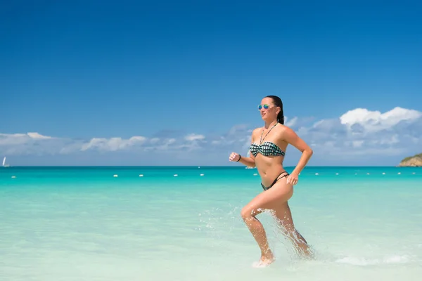 Chica en bikini ejecutar en la playa en st johns, antigua. — Foto de Stock